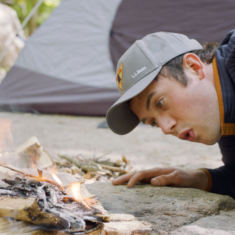 Nate gently blowing on the base of the fire.