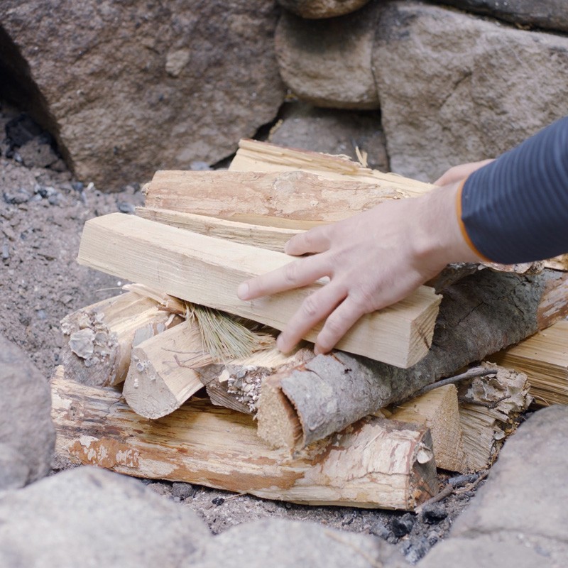 Nate adding a third layer of fuel logs to the fire.