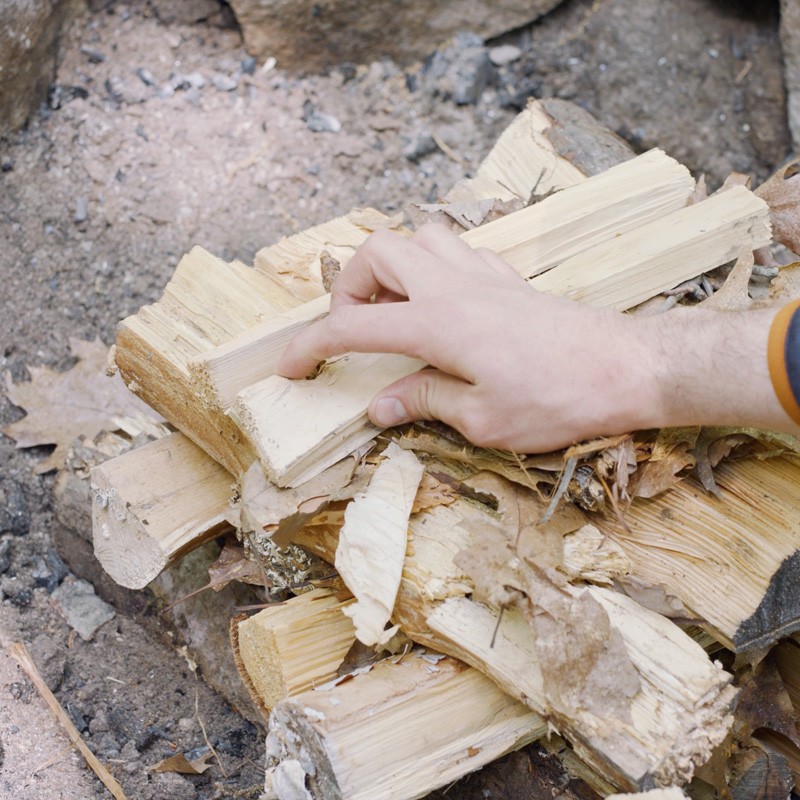 Nate adding tinder and kindling to the top of the fire structure.