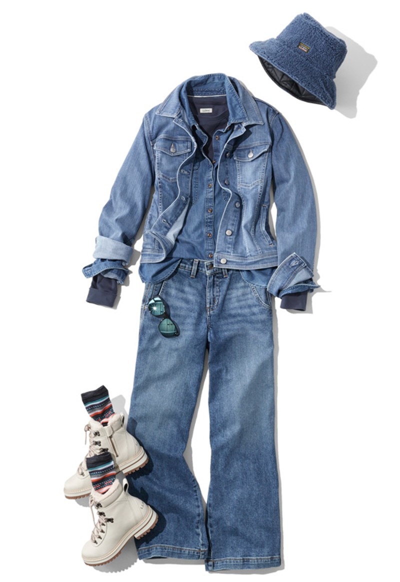 A laydown of an outfit featuring jeans and boots and all things denim, propped with sunglasses and a denim bucket hat.