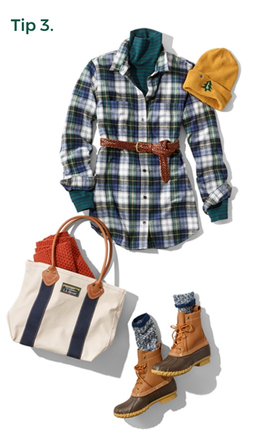 3. A laydown of an outfit propped with a tote bag and a knit hat.
