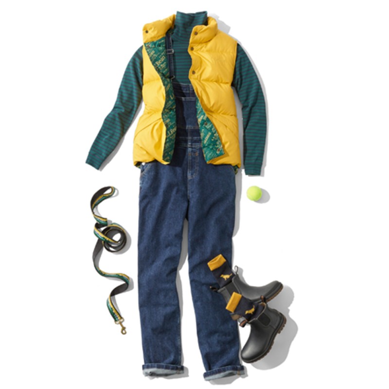 A laydown of an outfit featuring a bright yellow puffer vest, propped with a dog leash and a tennis ball.