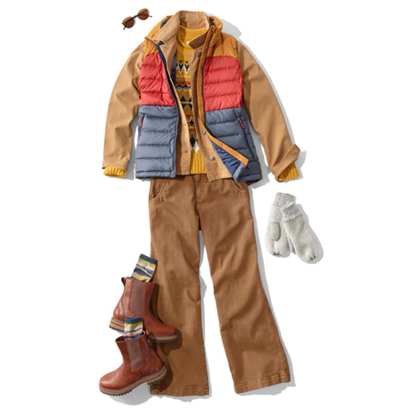 A laydown of an outfit featuring a colorblock vest over a jacket, propped with sunglasses and mittens.