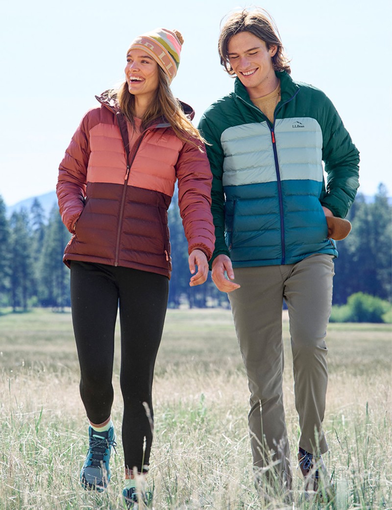 Happy couple walking outside wearing down jackets.