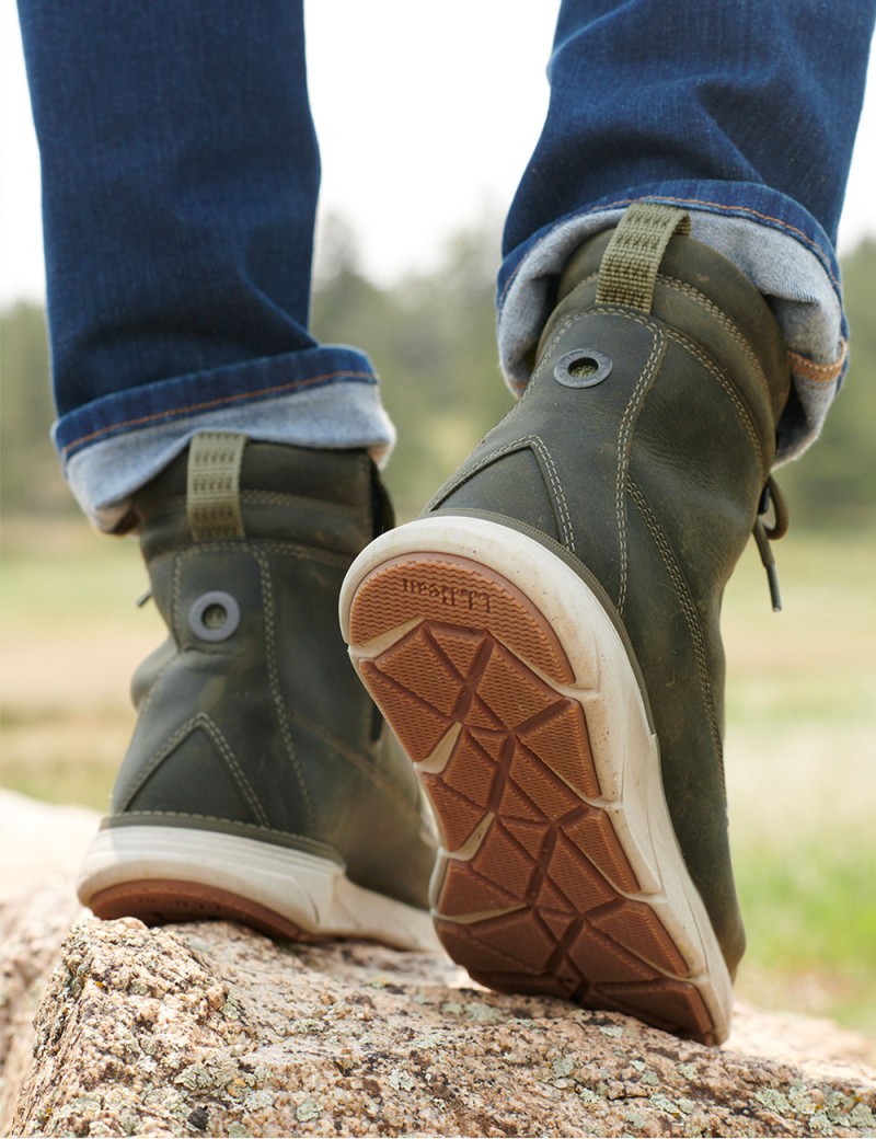 A close-up of boots on feet outside on a rock.