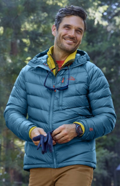 Man wearing insulated jacket outside with trees in the background