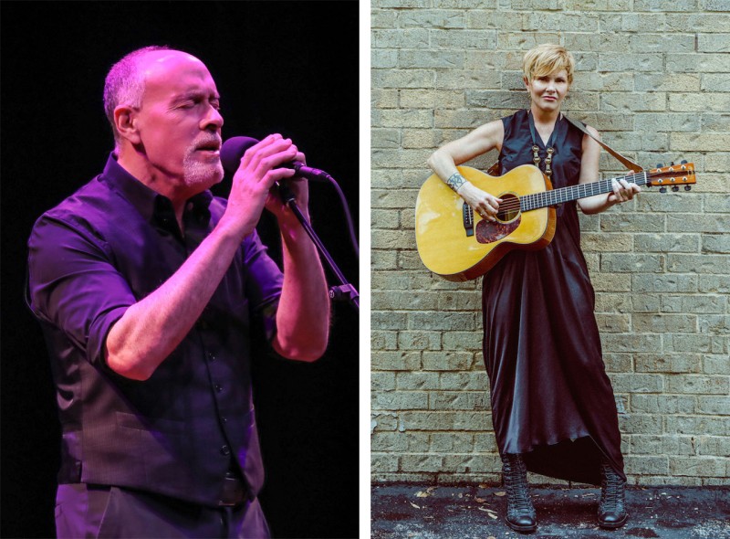Marc Cohn at a microphone and Shawn Colvin with her guitar in front of a light brick wall.