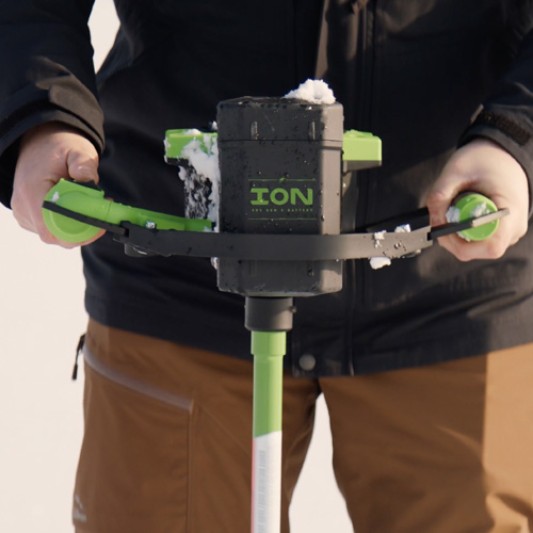Close-up shot of someone holding the handles of an ice auger.