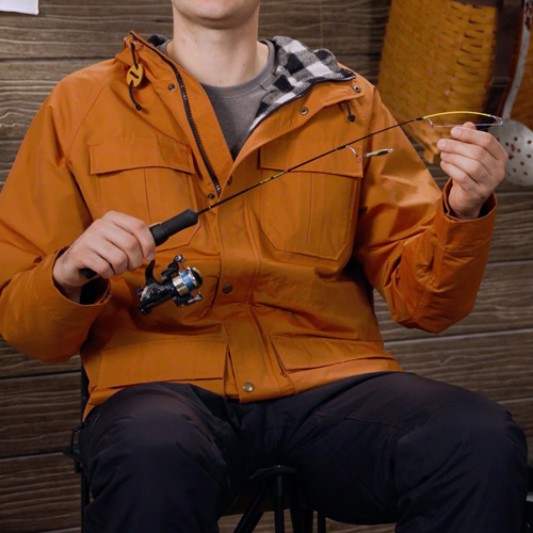 Close-up of a person holding a jig rod with lure.