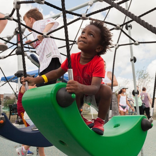 A smiling child enjoying the community park playground.