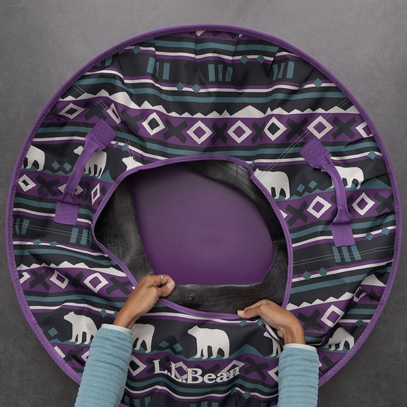 Hands insert an inner tube into a L L Bean Sonic Snow Tube.