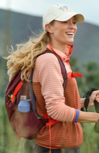 Young woman wearing a hiking pack with a water bottle