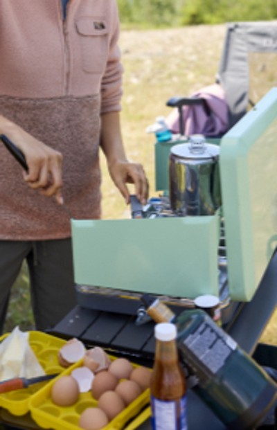 Woman cooking on a camp stove.