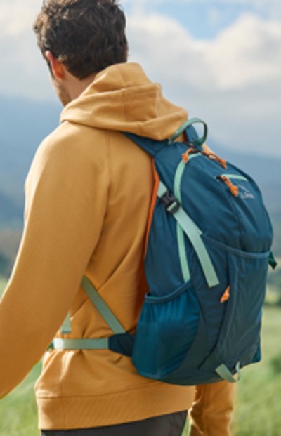 Man wearing a yellow hoodie also wearing a hiking pack
