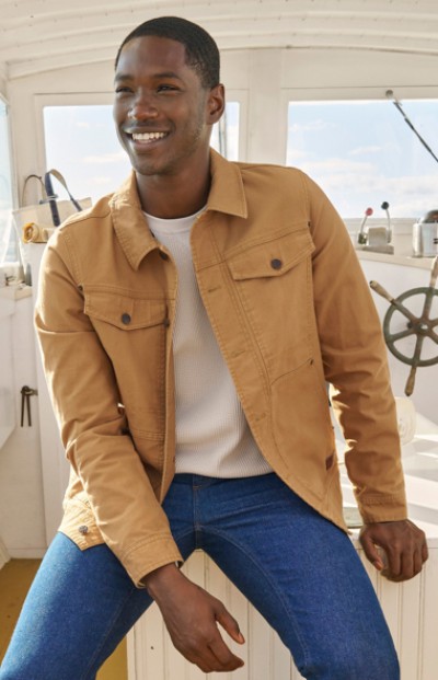 Man wearing casual jacket while riding on a boat.