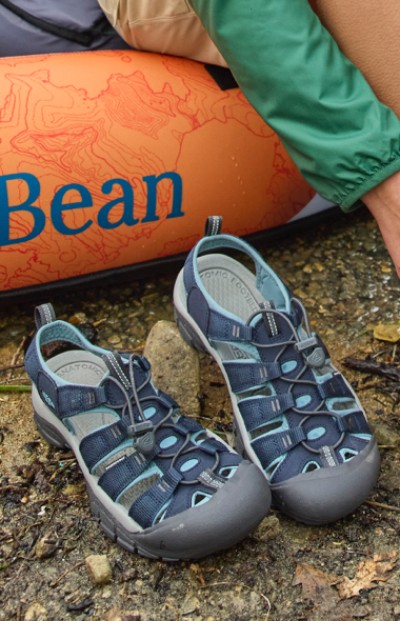 Image depicting water shoes next to a kayak with the LL Bean logo on it.