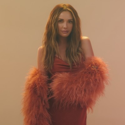 Carly Pearce wearing an orange dress and boa.