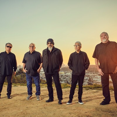 the 5 members of "Los Lobos" band in the desert at twilight.