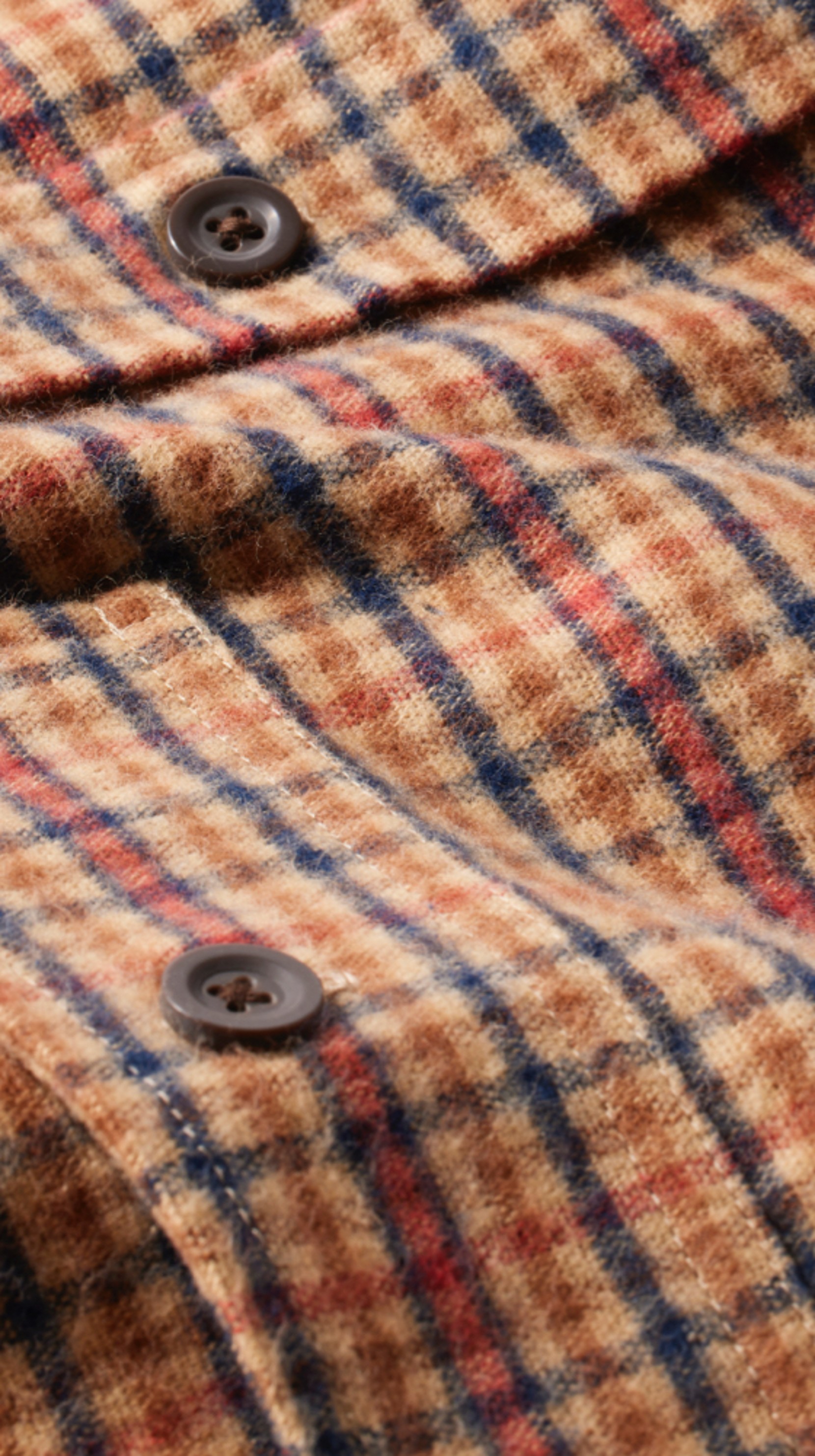 A close-up detail image of a plaid L L Bean Chamois shirt with buttons.