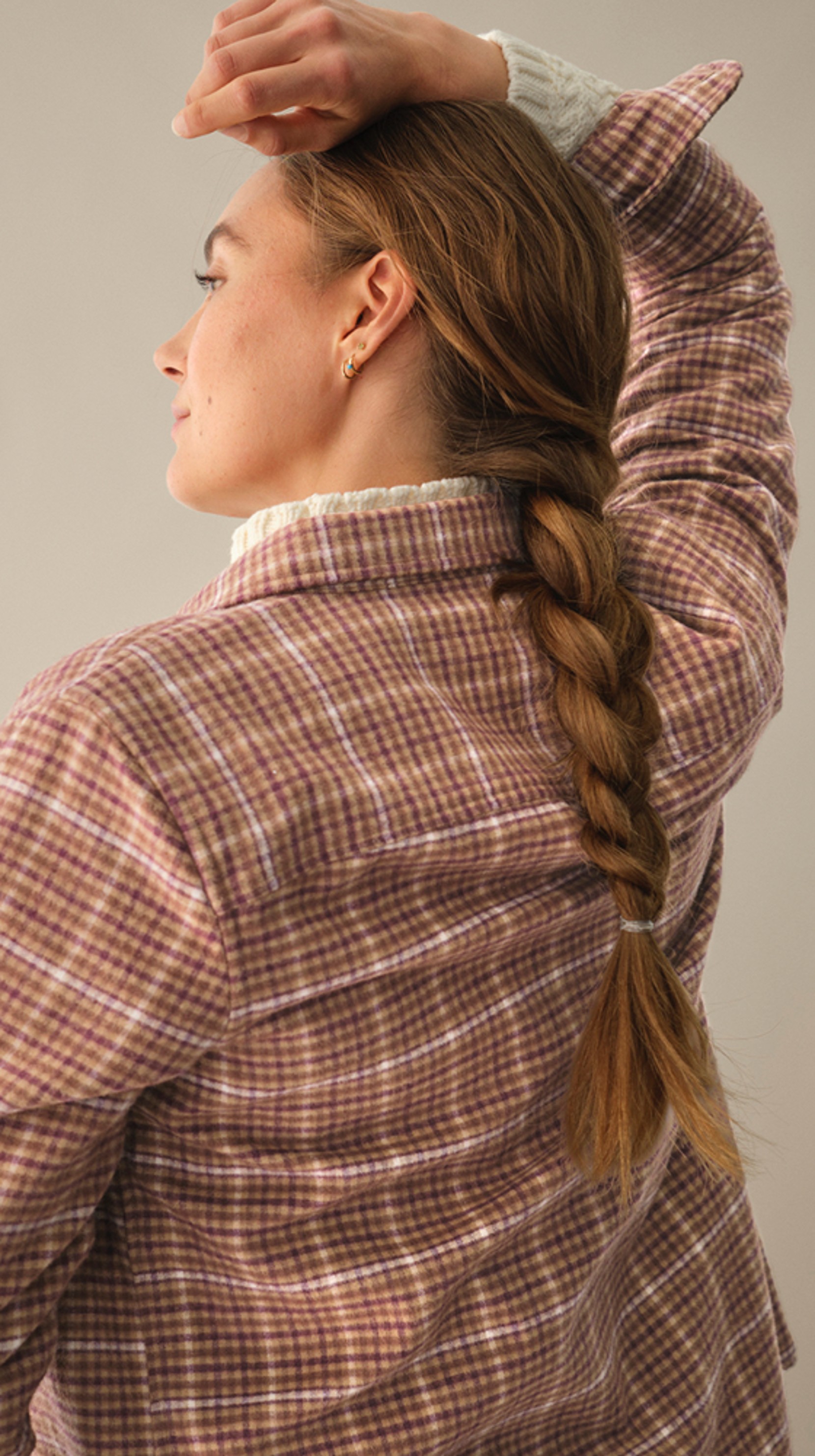 A woman with a braided ponytail, wearing a L L Bean Chamois shirt, is seen from behind.