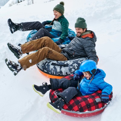 A family having fun sliding on snow using the Sonic Snow tube