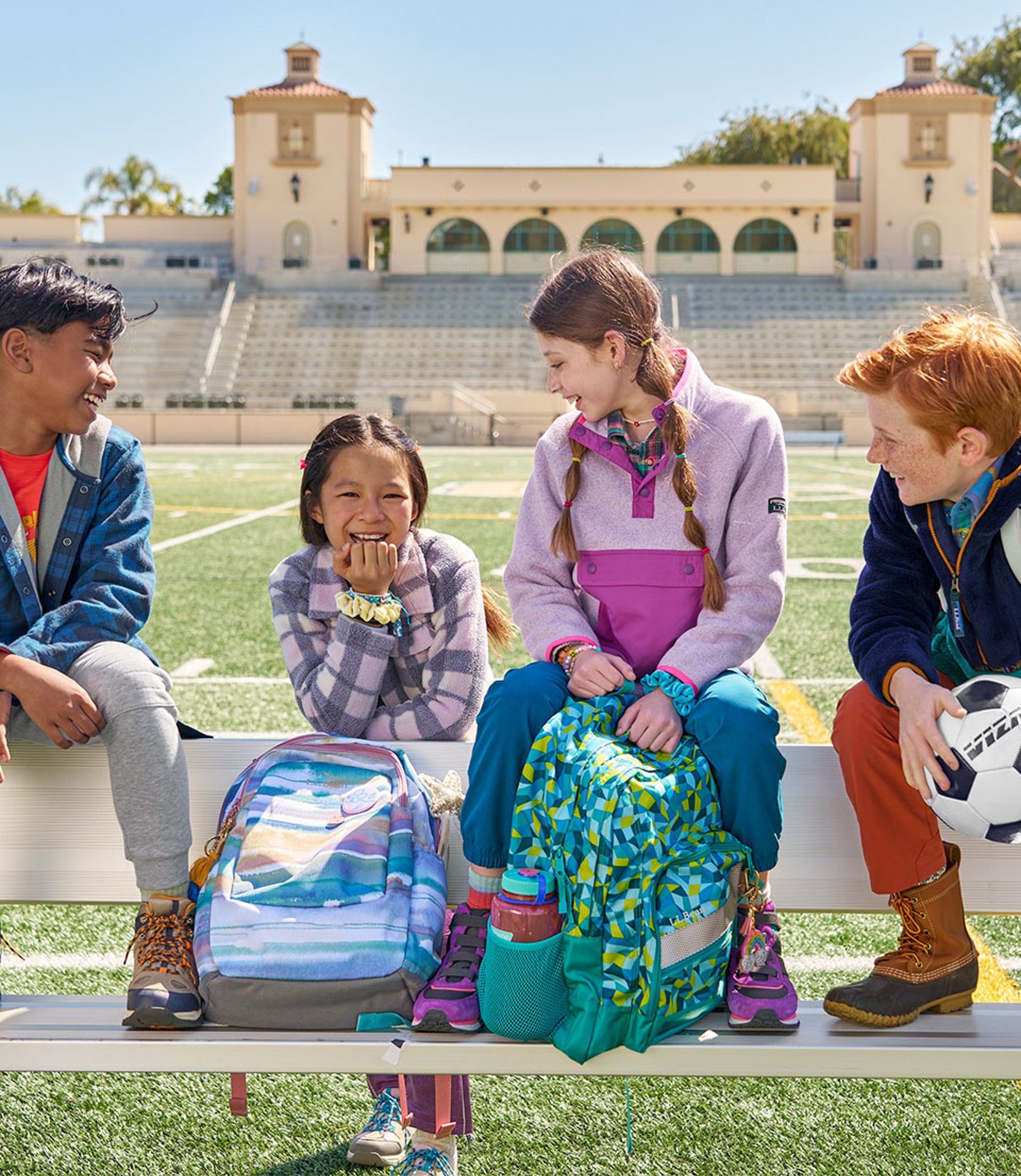 A group of smiling children with L.L.Bean backpacks.