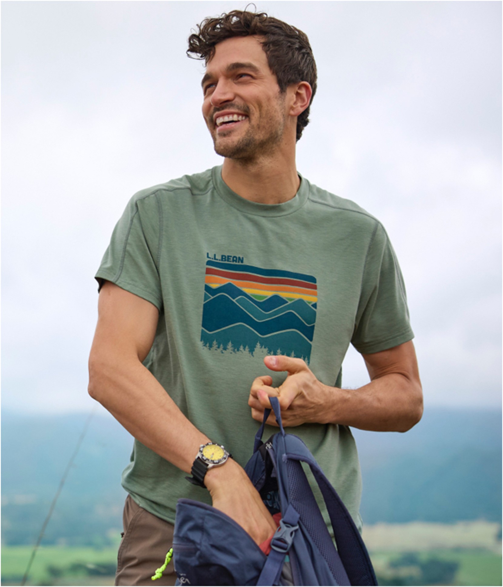 A man standing outside in a Sunsmart Tee reaching into his day pack.