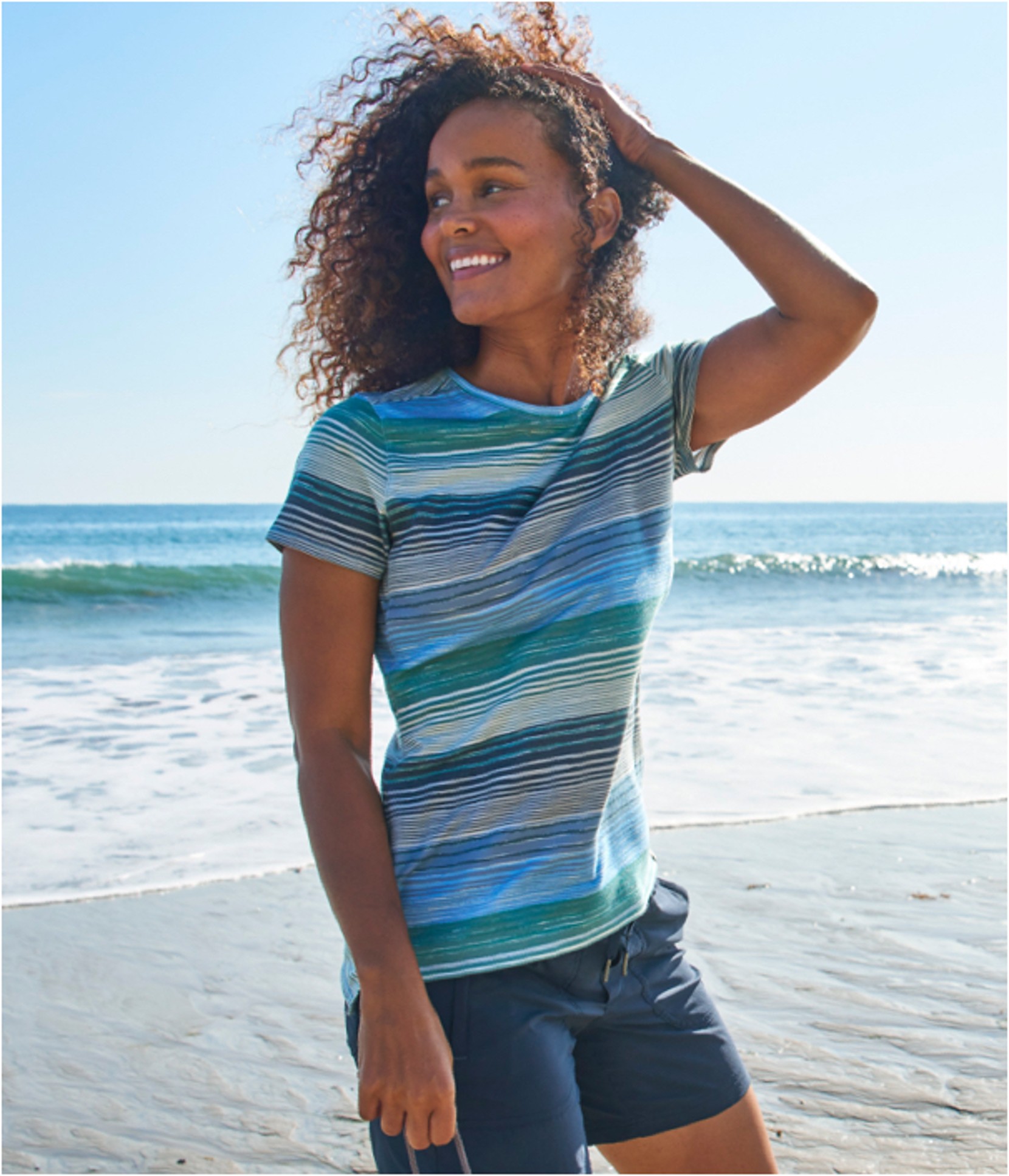 A woman standing outside at the beach in a Sunsmart Tee.
