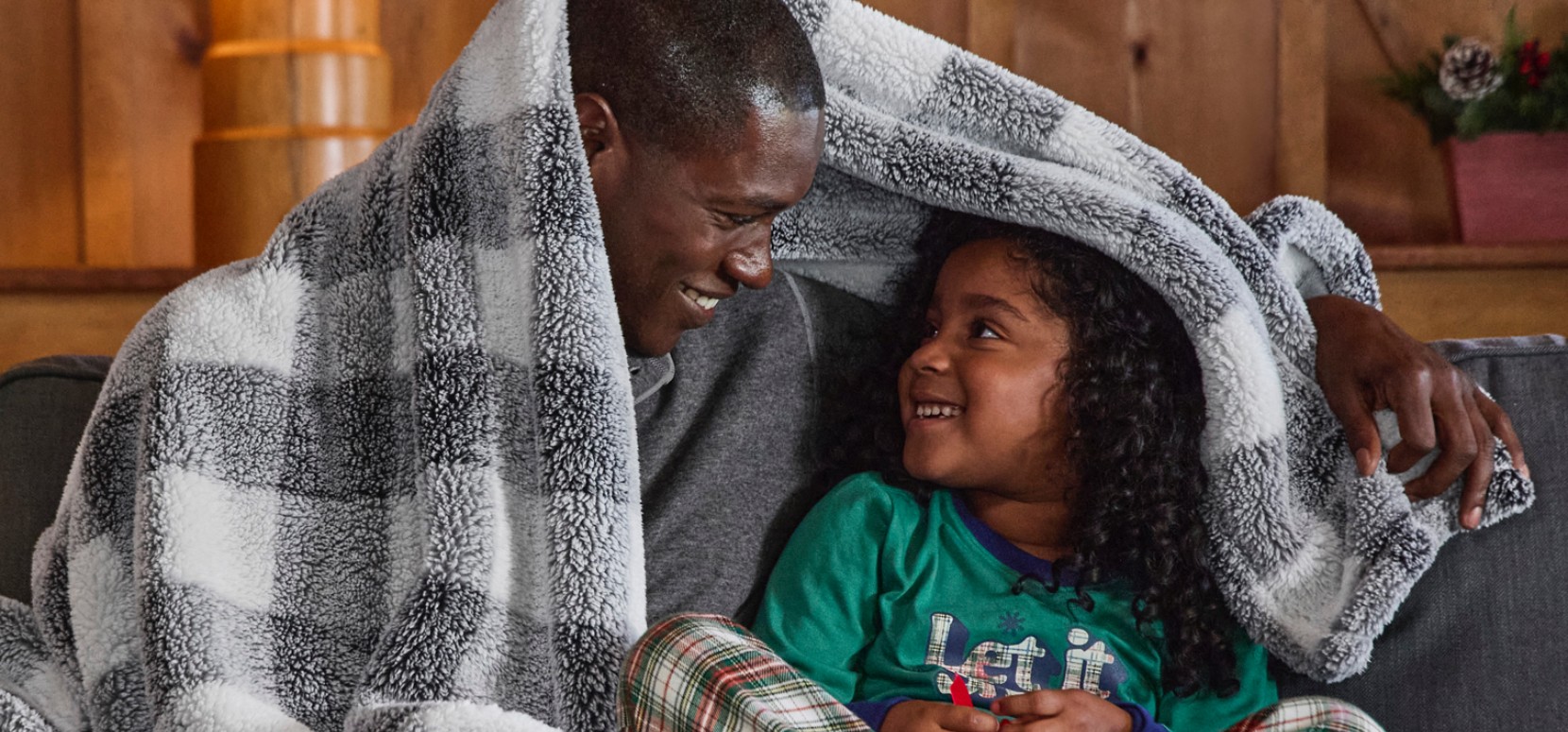 Two people huddled under a cozy plush fleece throw