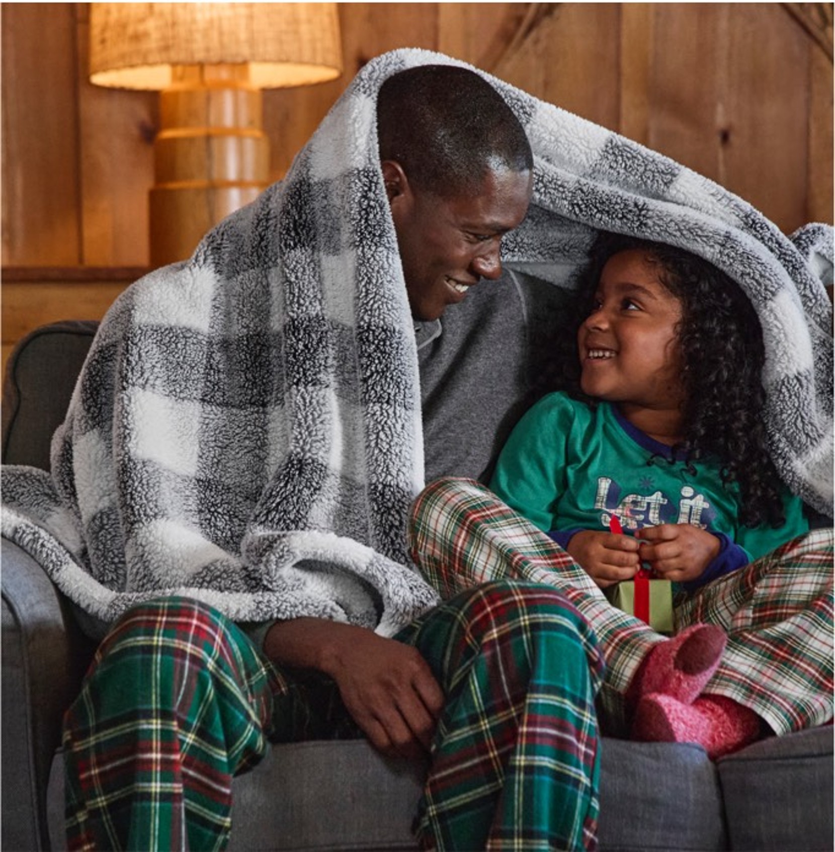 Two people huddled under a cozy plush fleece throw.