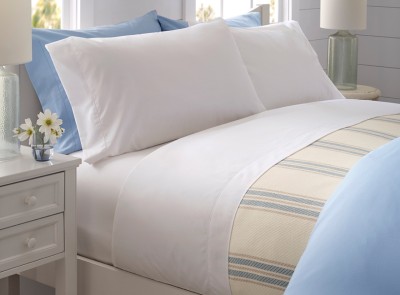 A neatly folded bed with plush, white pillows awaits a tired person.