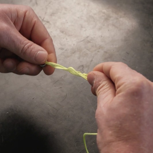 A fishing line knot is moisted with water.