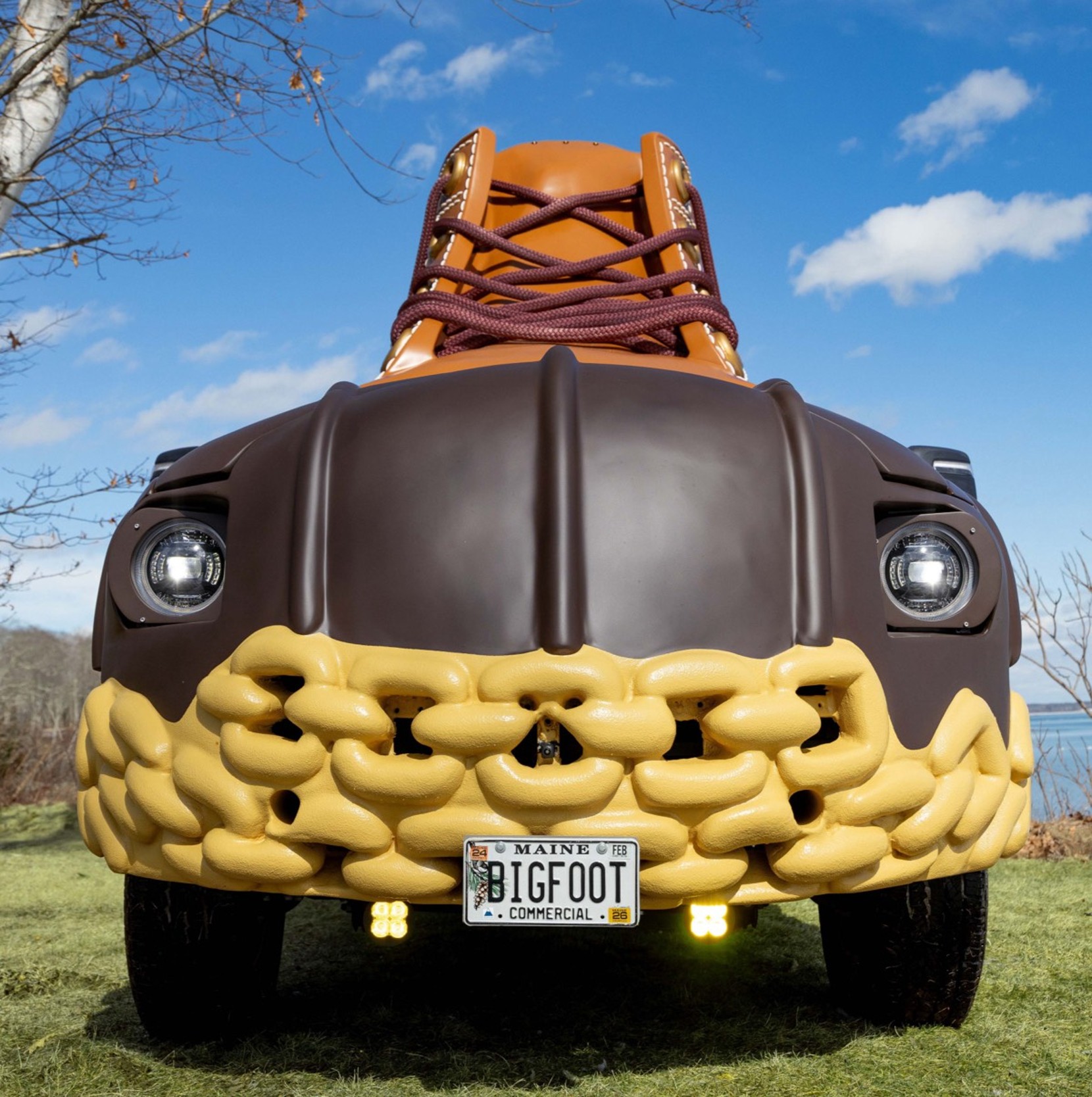 A vehicle designed to look like a giant L L Bean Boot with laces, featuring a Maine license plate that reads BIGFOOT.