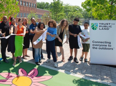 A group of smiling people at a ribbon cutting ceremony.