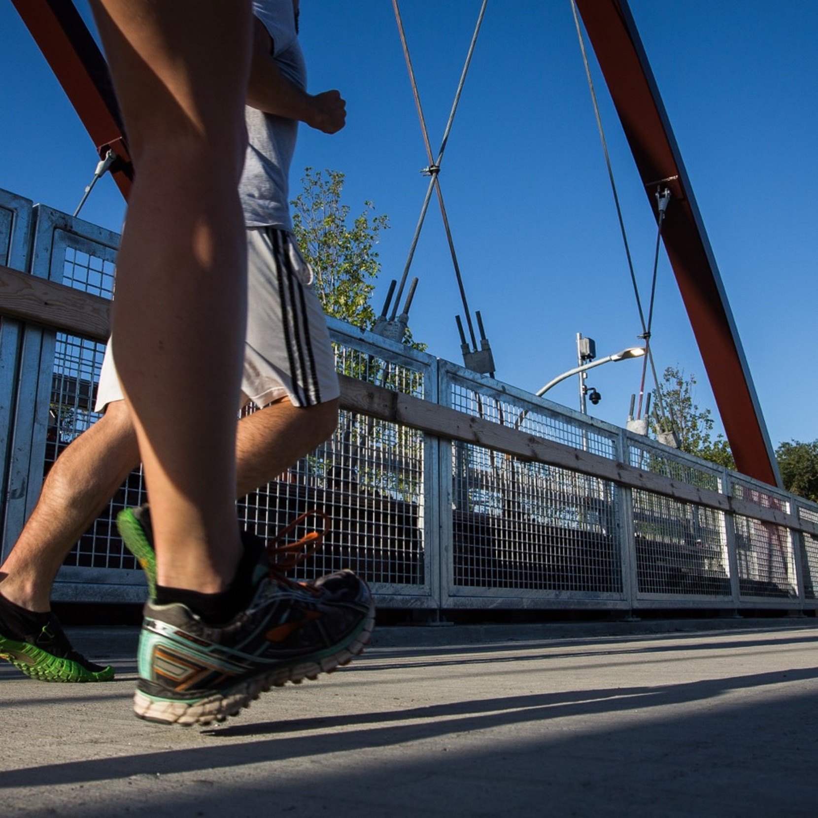 Close up of feet running on a bridge outside.