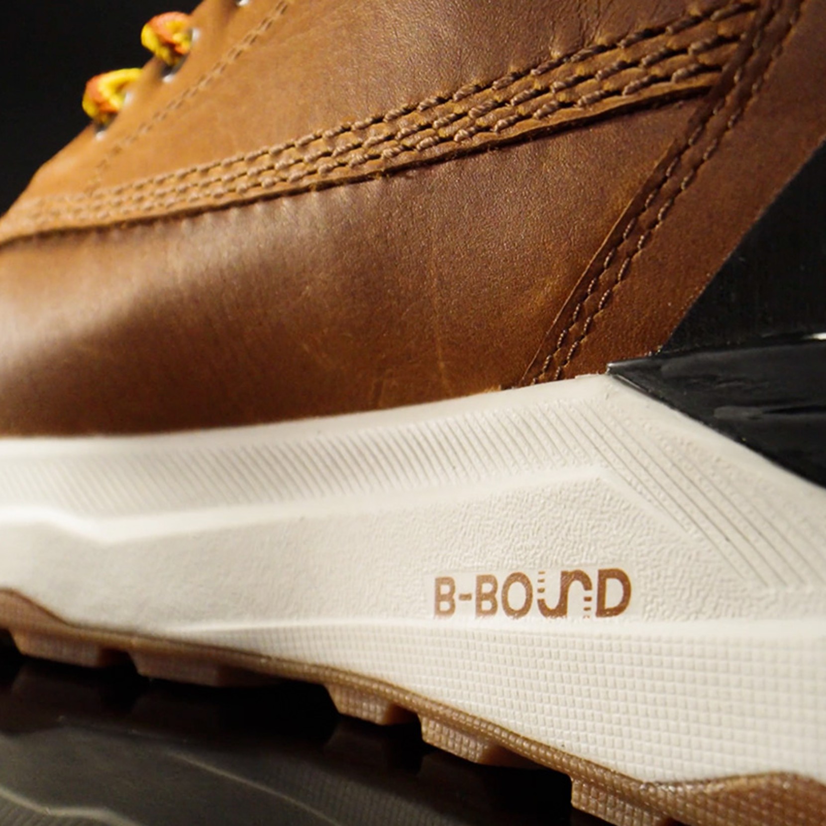 Close-up of brown leather shoe with white sole and "B-BOUND" branding in brown text on the side.