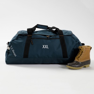 Extra extra large teal L L Bean duffle bag with black straps, shown next to a tan Bean Boot.