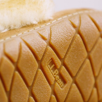 Close-up of a tan rubber sole with diamond tread pattern and LL Bean logo, topped with soft cream fleece lining.
