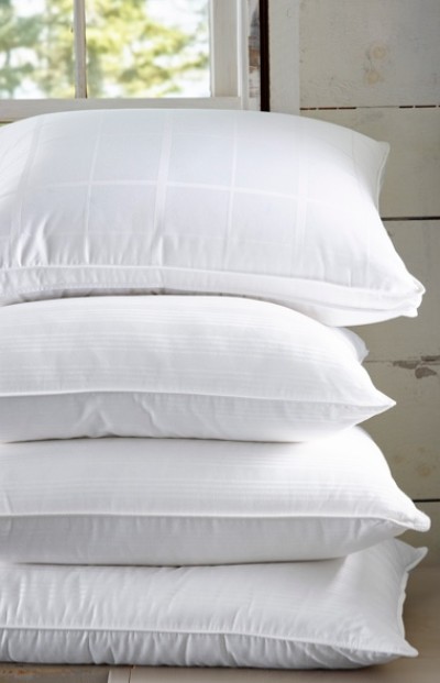 A stack of four white plush pillows. 