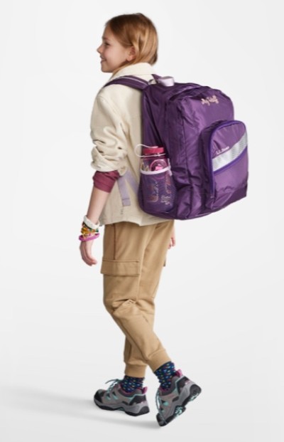 Young woman wearing a purple school backpack.