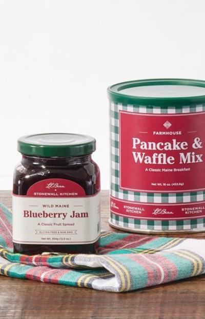 Jar of Wild Maine Blueberry Jam and Pancake & Waffle Mix canister displayed on a plaid cloth.