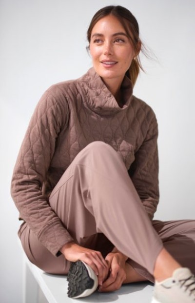 Person in quilted mauve pullover with a high collar paired with matching relaxed-fit pants, styled for a cozy casual look.