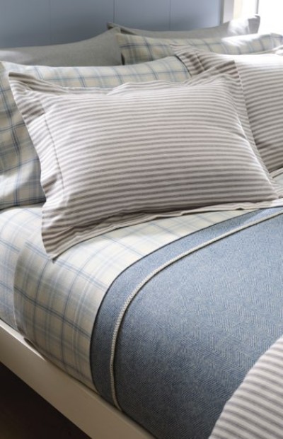Blue and gray bedding set featuring plaid sheets, striped pillowcases, and a textured blue blanket for a cozy layered look.