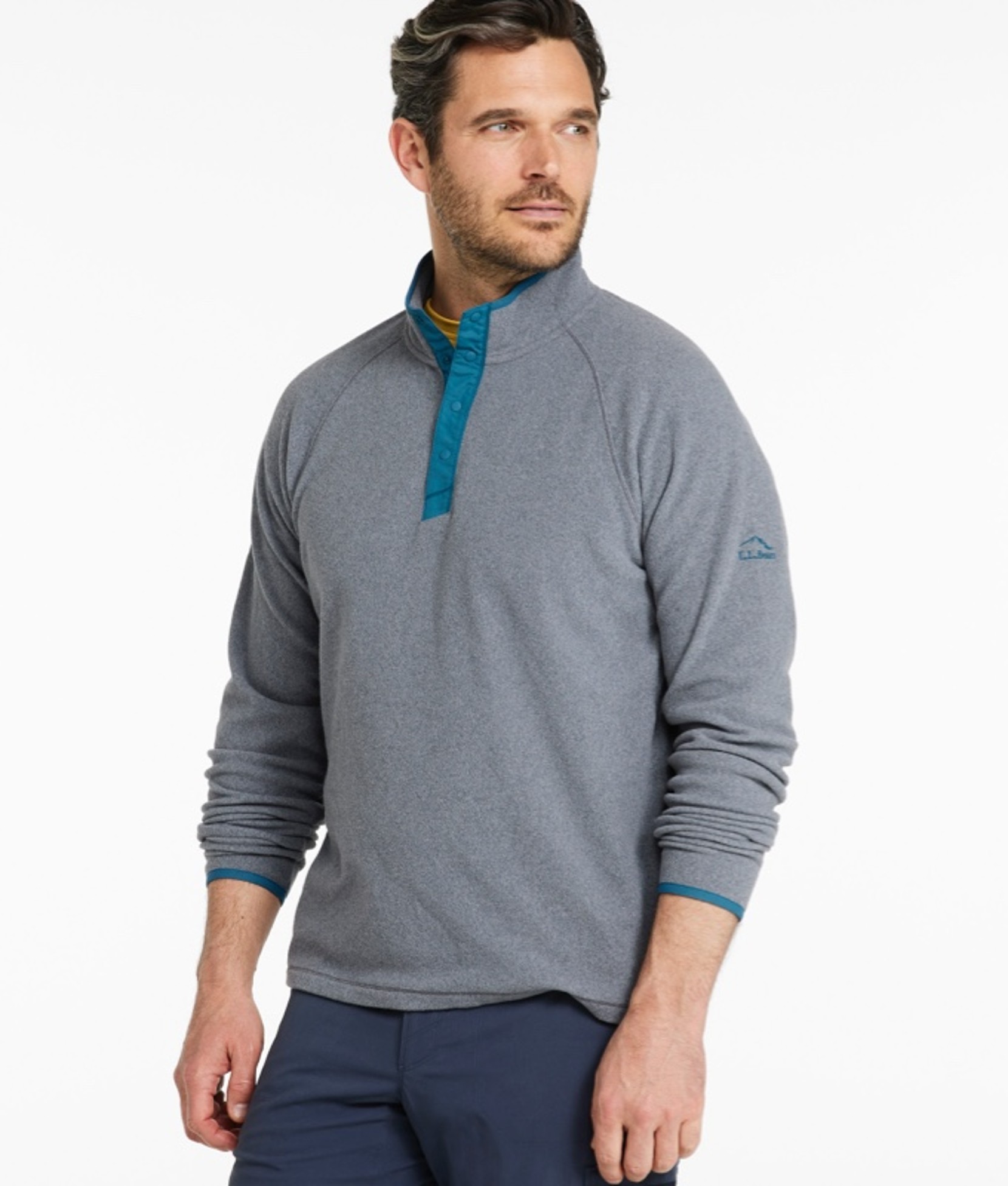 A thigh-up shot of a man wearing a quarter-snap pullover.