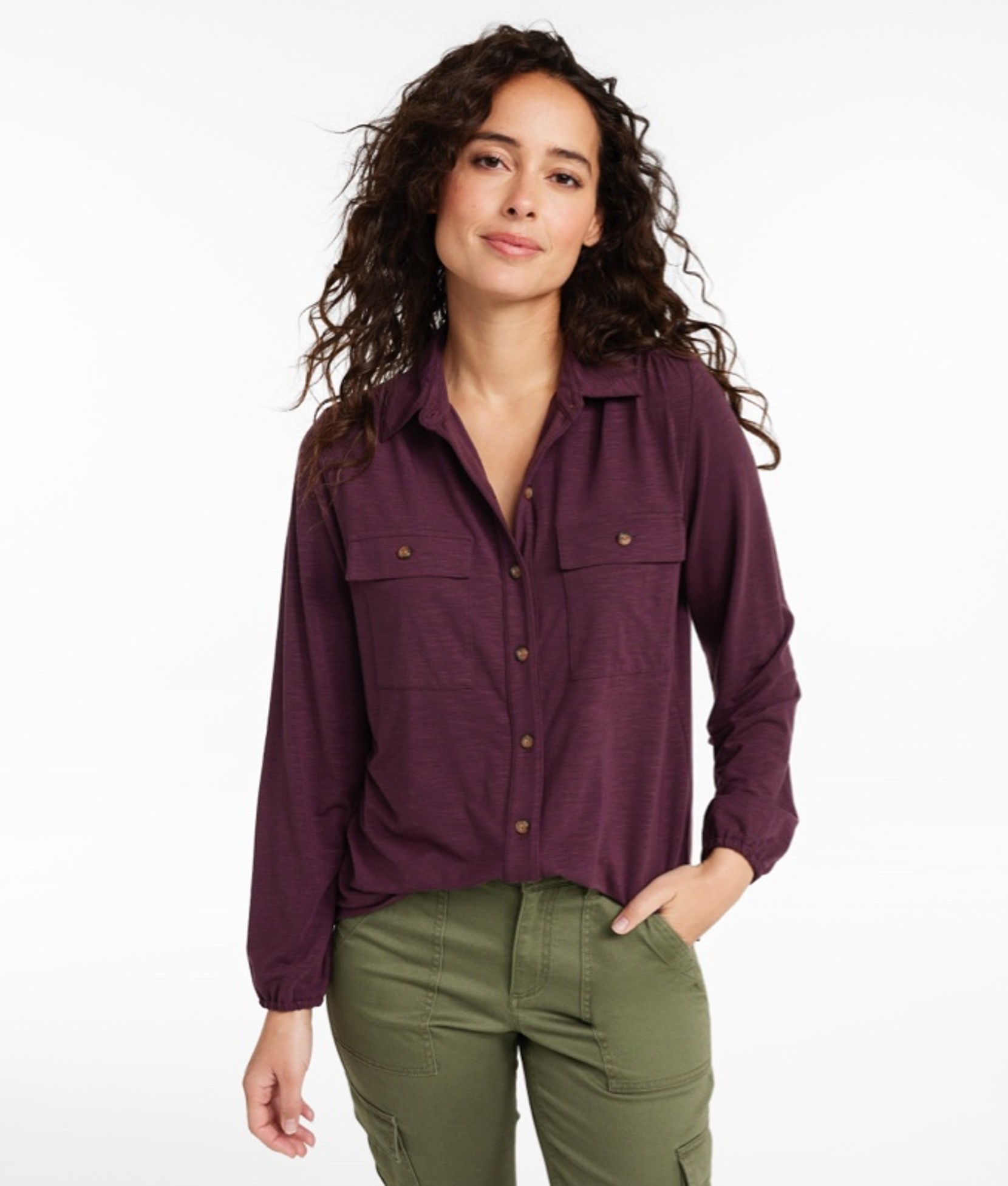 A thigh-up shot of a woman wearing a button-down shirt and pants.
