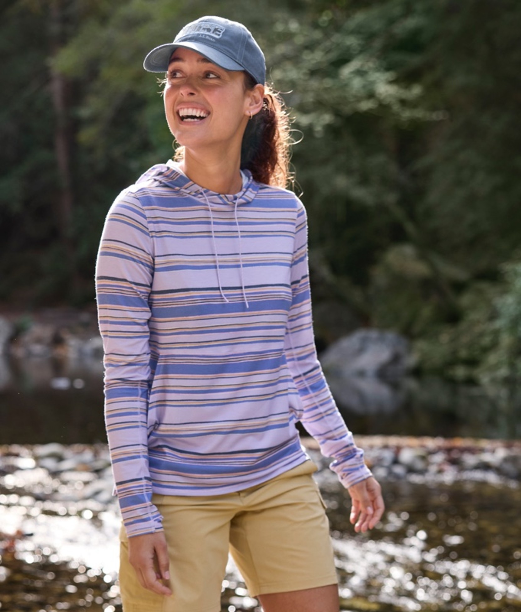 A woman walking near a stream.