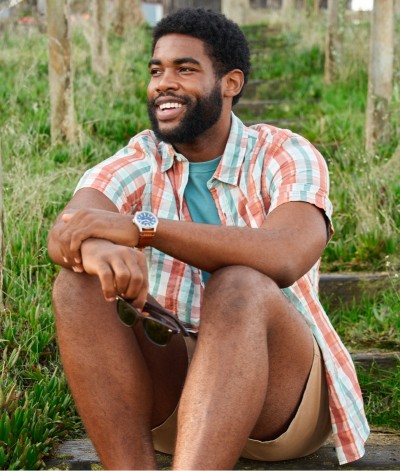 Man outside in summer sitting on a bench.