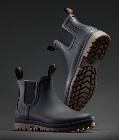 Black L L Bean Wellie boots with brown pull tabs and rugged soles, one upright and one tilted to show tread pattern.