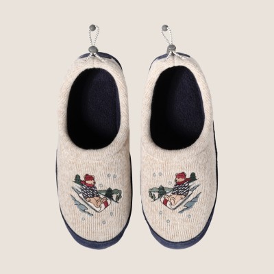 Cream slippers with fleece lining and sledding bear embroidered on top.