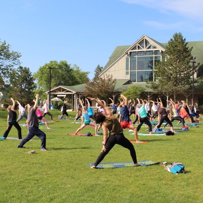 People practice yoga on the lawn in front of the L L Bean flagship store.